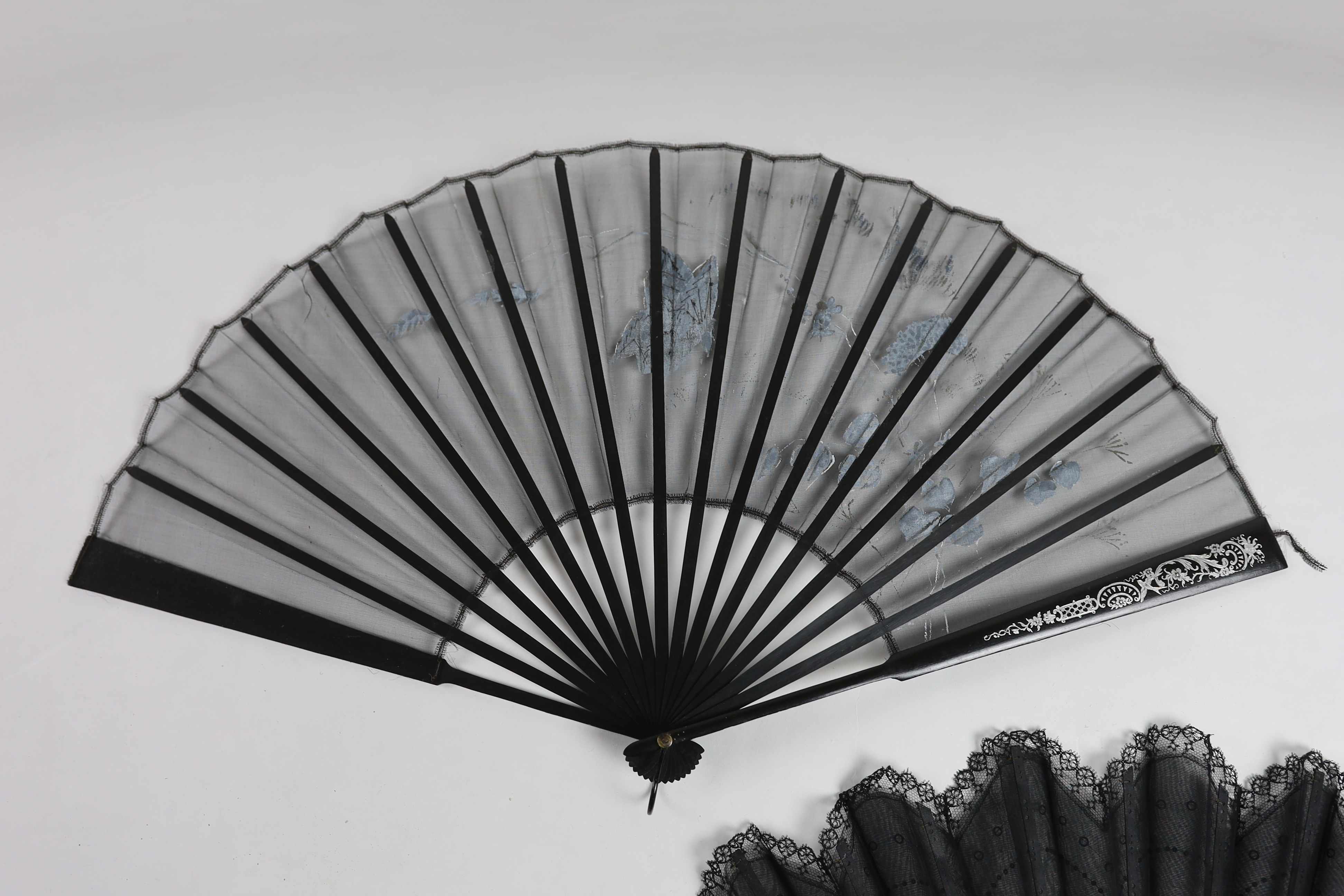 An Edwardian black silk and ornate sequin fan, a similar fan with carved ebony guards and a fine gauze fan with painted sprig and butterfly decoration (3)